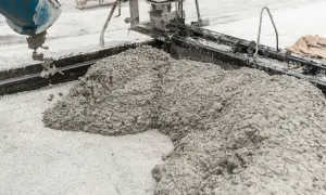 Świeża podsypka piaskowo cementowa wylewana z betoniarki na plac budowy.