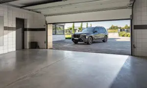 Nowoczesny garaż z betonową posadzką, idealny na jaki beton na posadzkę w garażu. Ciemny SUV czeka przed wejściem.
