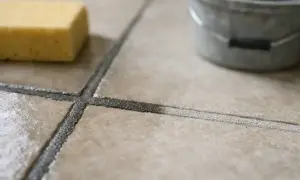 Gąbka i wiaderko obok świeżo położonej fugi. Czekamy, aż fuga schnie, by móc dokończyć prace.