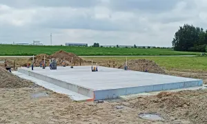 Płyta fundamentowa z betonu, gotowa do dalszych prac budowlanych. Widać instalacje i zbrojenie.
